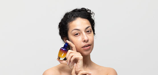 A woman holding the L'OCCITANE Overnight Reset Serum