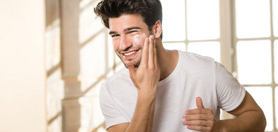 A man moisturising his face with L'OCCITANE Cade Revitalising Cream