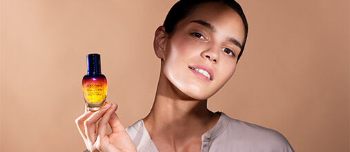 A woman holding the L'OCCITANE Immortelle Overnight Reset Eye Serum 