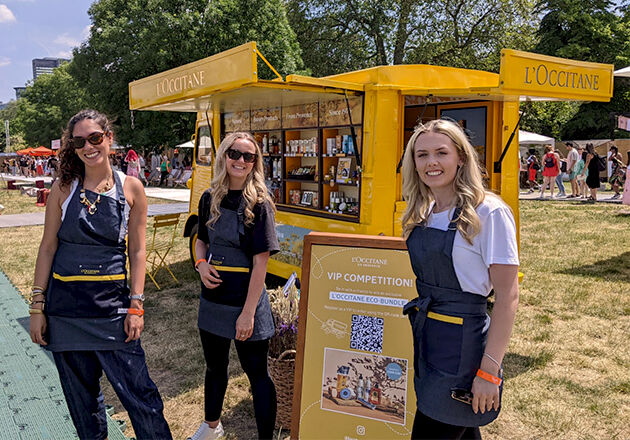 L'OCCITANE Brand Ambassadors standing next to the iconic L'Occi Yellow Truck at Taste of London Festival 2023, London, Regents Park   