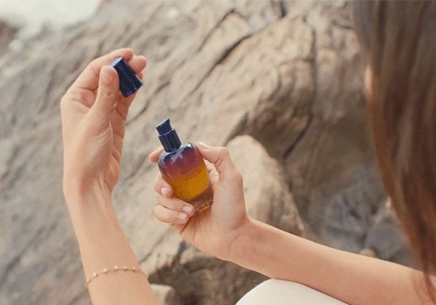 Woman holding L'OCCITANE Overnight Immortelle Reset Serum 