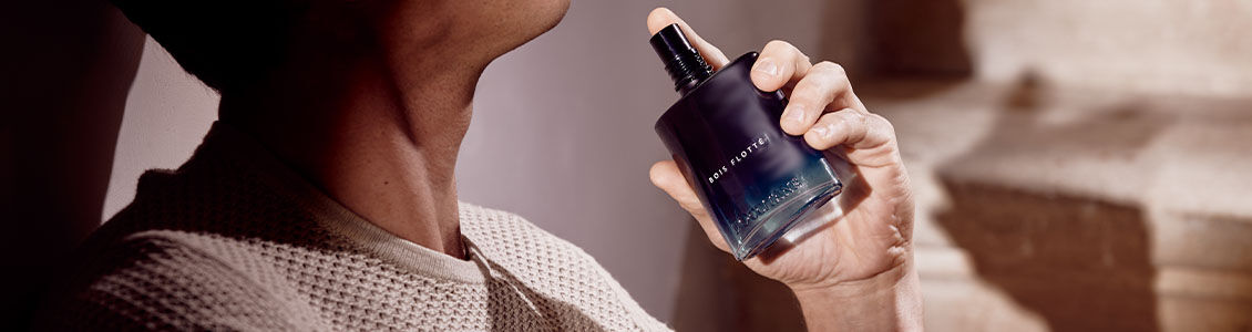A man spritzing the L'OCCITANE mens Bois Flotte Eau de Toilette onto his neck