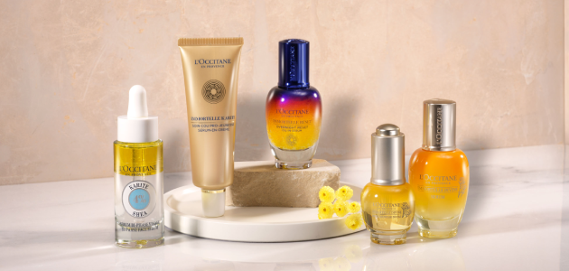 This image shows a woman holding the L'OCCITANE Reine blanche Illuminating Serum