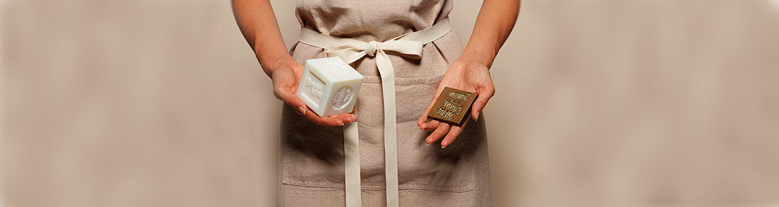 Craftswoman holding L'OCCITANE Bonne M&egrave;re Soap Bar and stamp used in the manufacturing process, Savon de Marseille, Provence