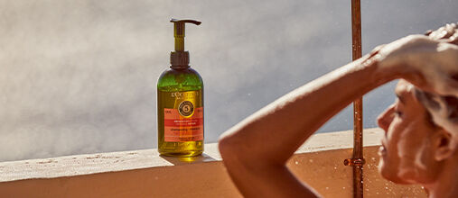 Woman using L'OCCITANE Intensive Repair Shampoo