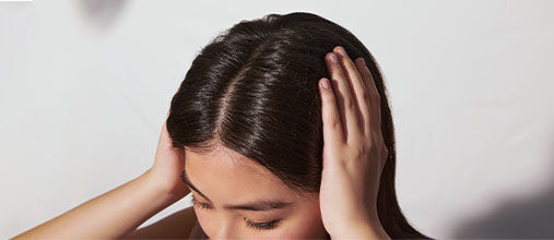 The image shows the head of a woman focusing on the scalp