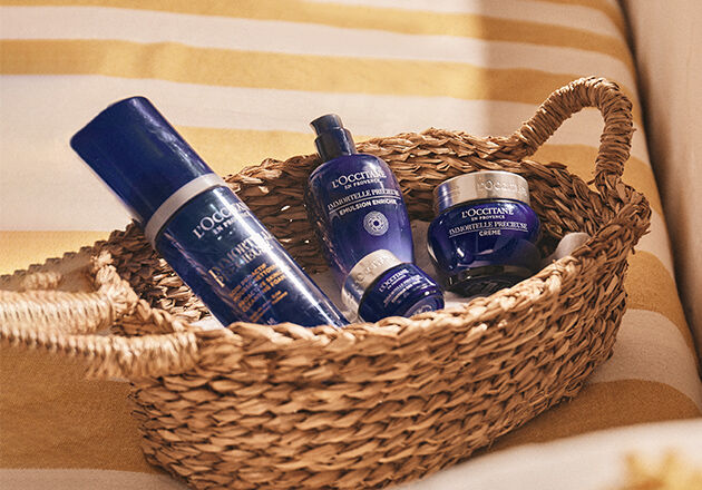 This image shows a basket full of the L'OCCITANE Immortelle Precious Cleansing Foam, L'OCCITANE Immortelle precious Eye Balm, L'OCCITANE Immortelle precious Eye cream.