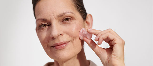 Woman massaging L'OCCITANE Skincare to prevent ageing 