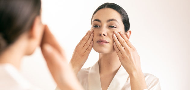 image shows a woman gently massaging her face