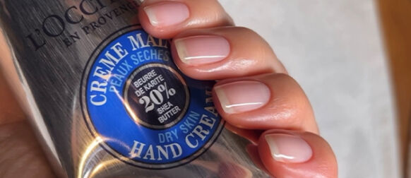 Woman using L'OCCITANE Shea Nail & Cuticle Nourishing Oil