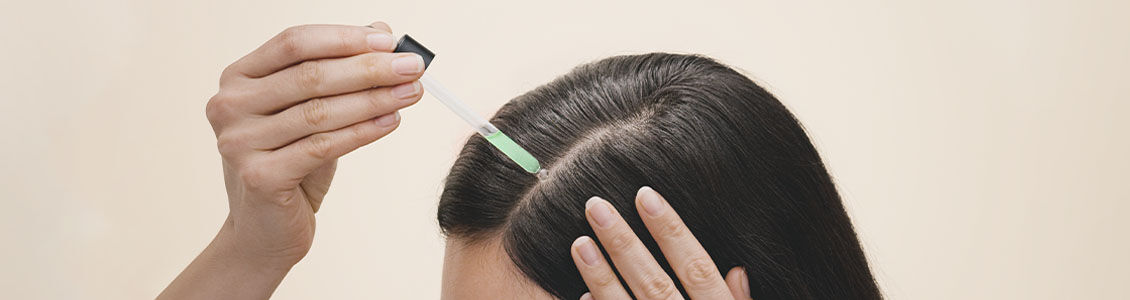 Woman applying L'OCCITANE Anti-hair loss Serum