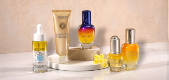 This image shows a woman holding the L'OCCITANE Reine blanche Illuminating Serum