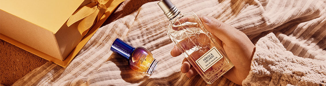 The image shows a person holding the L'OCCITANE Neroli & Orchidee Eau de Toilette