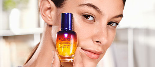 Woman holding Immortelle Overnight Reset Serum.
